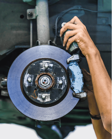 Hands of a mechanic install brake lining onto a car disc brake